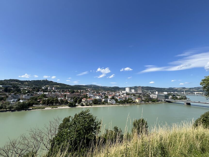 picture of the river Danube with buildings of the city Linz on the other side of the shore